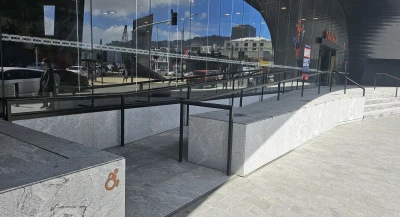 Concrete ramp leading to glass doors with Marvel themes attractions on the window.