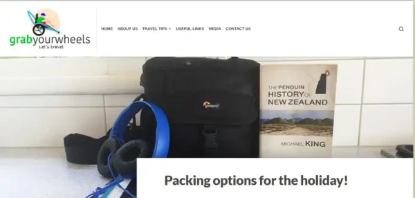 Grab your wheels website features bag and headphones next to a History of New Zealand magazine.