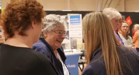  A glowing senior lady engaged in a warm conversation with a supportive healthcare advisor.