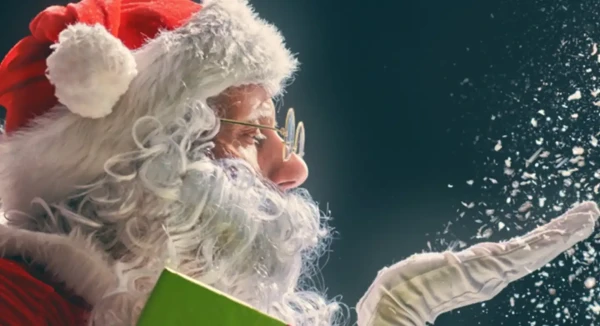 Santa is blowing snow off his palm. 
