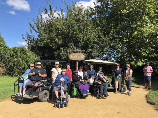 Image of group of people at hobbiton in various mobility equipment