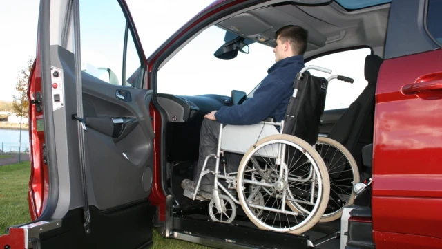 A man in a wheelchair positioned in the front passenger position of wheelchair-accessible car