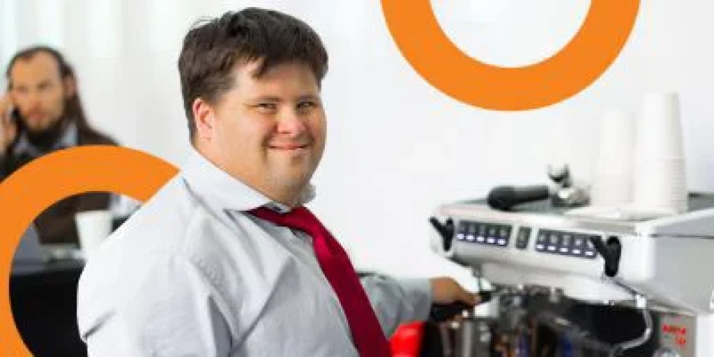 A man with Down syndrome getting coffee in an office.