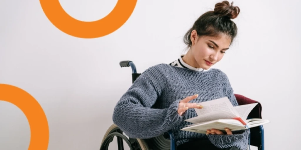A young woman in a wheelchair reading a book