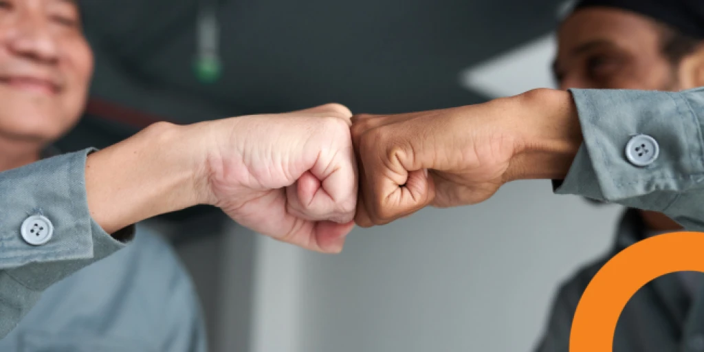 A close up of two men doing a fist bump