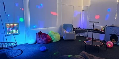 Sensory space room with lights beanbags, a swing, and rocking chair