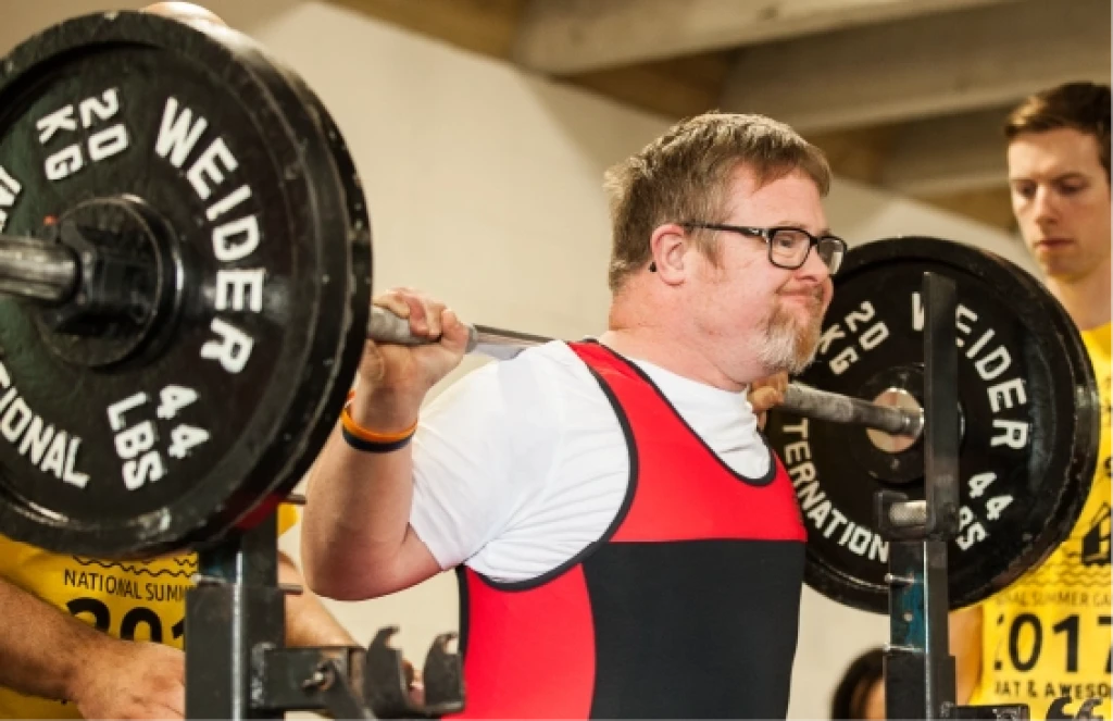 Man in a red singlet lifting a barbell