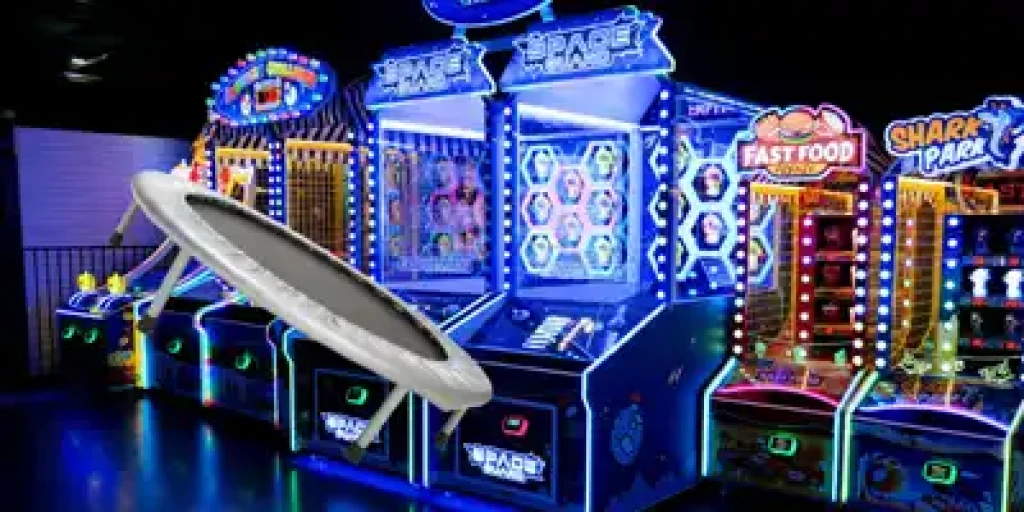 Neon lit set of 6 arcade games with a trampoline on in front.