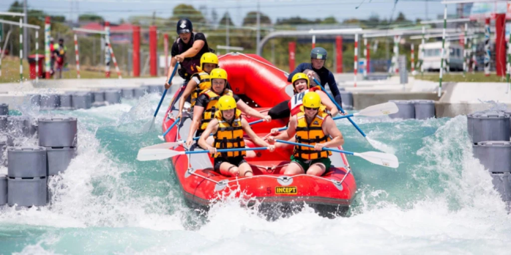 A group of people in a red raft riding down a rapid at Vector Wero Whitewater Parkk
