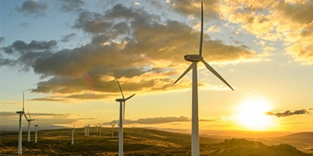 Wind turbines on hills at sunset