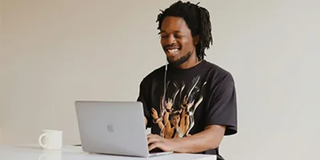A man sitting at a table working on a laptop