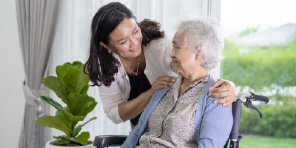 A woman caring for an older woman in a wheelchair