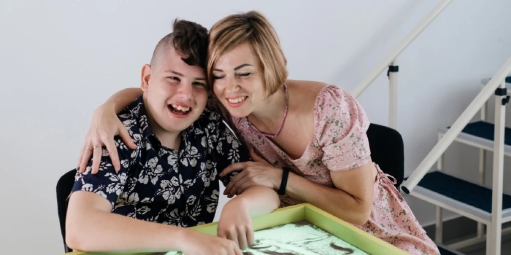 A disabled young man and his carer