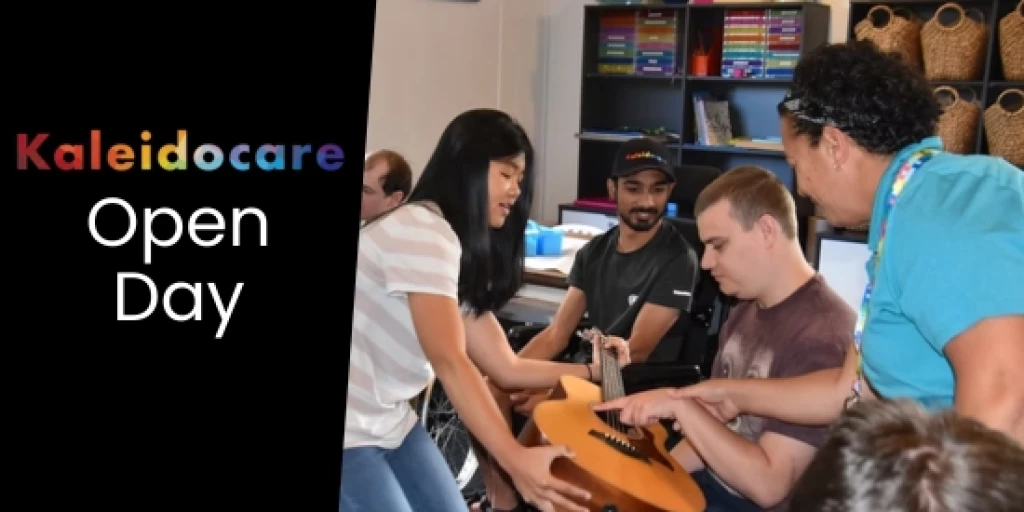 Two women showing a young man how to play guitar