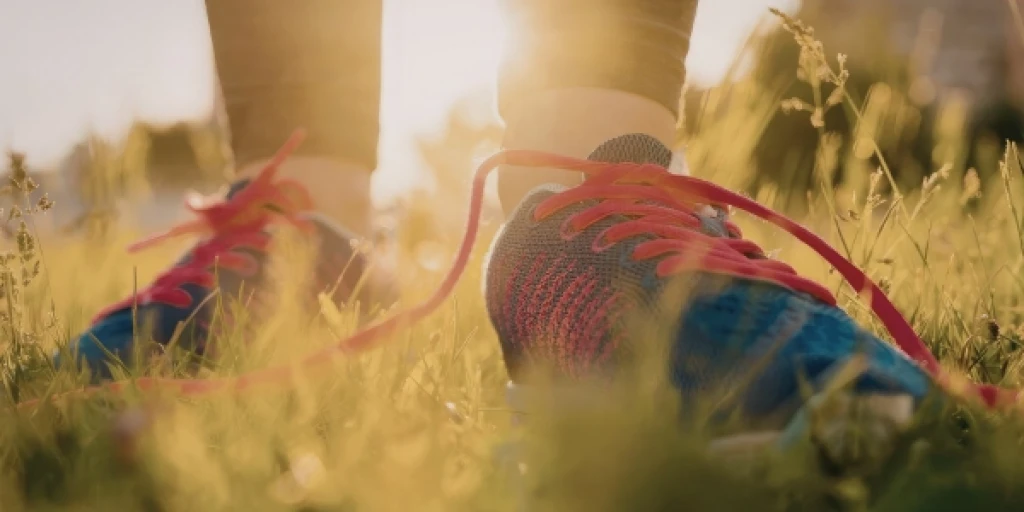 A close up of someone's feet wearing a pair of blue and red running shoes.