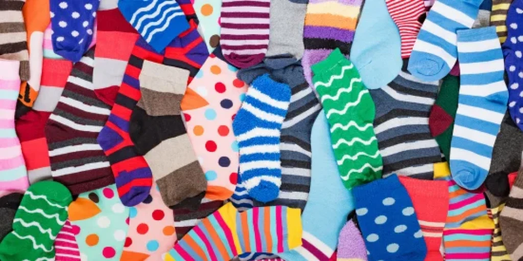 Various colourful socks spread out on the floor
