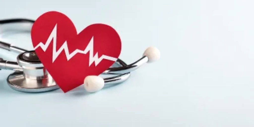 Ared paper heart sitting on top of a stethoscope